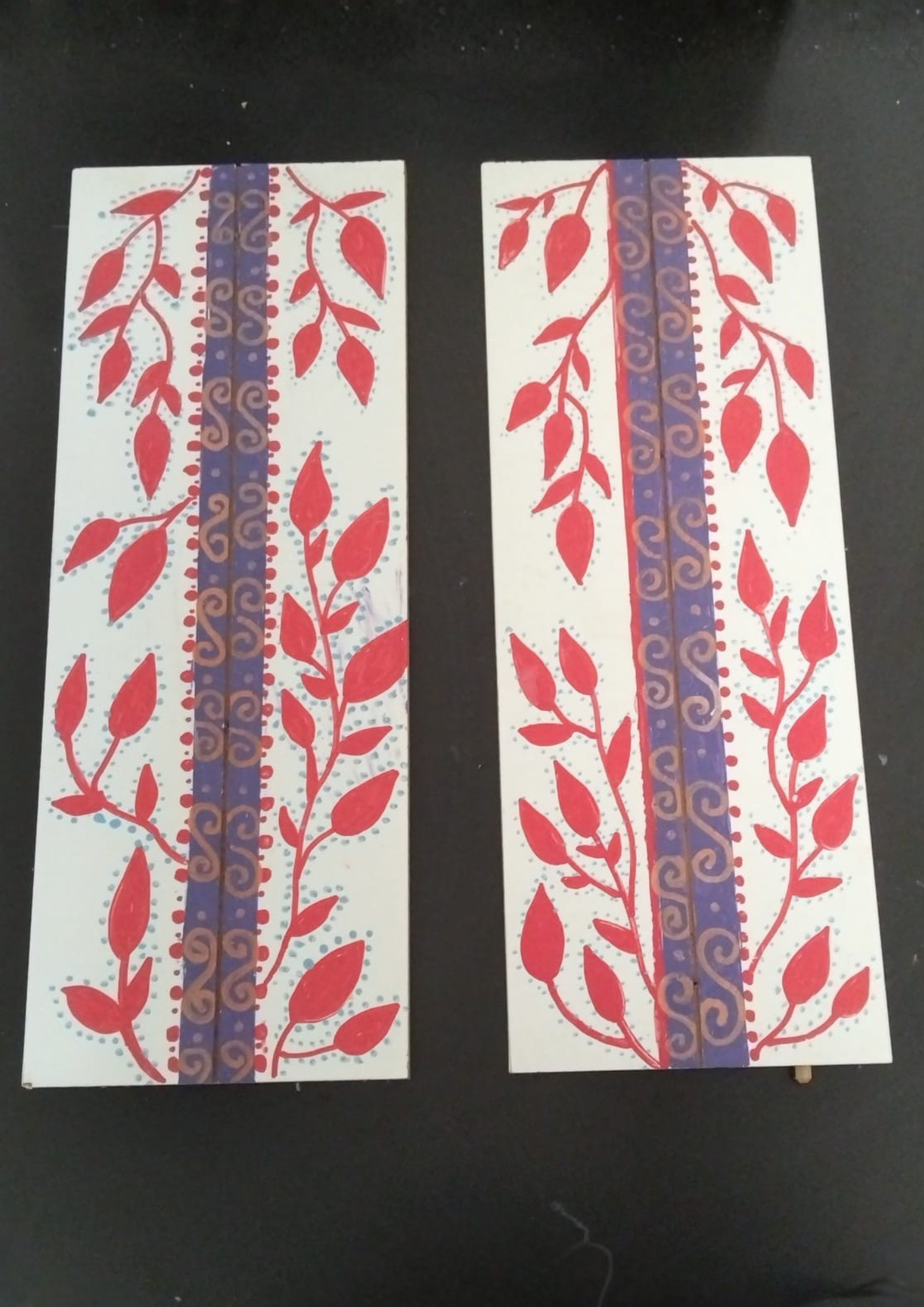 Placas retangulares com pintura de folhas em tom vermelho